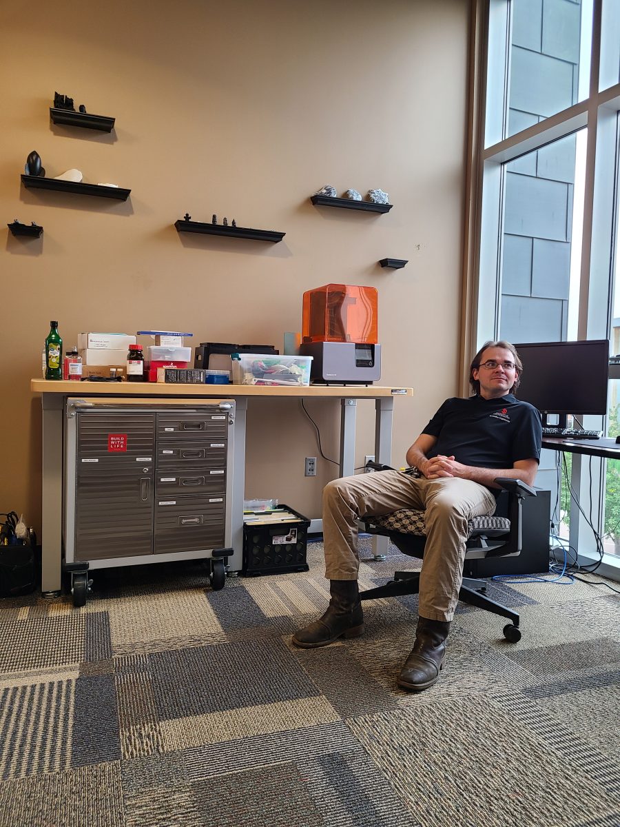 Tim Hartman sits in the 3D-printing lab space.