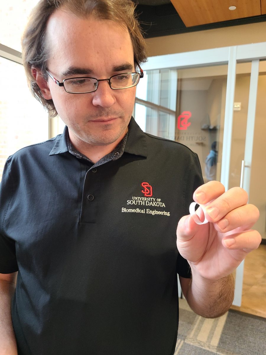Tim Hartman holds one of the ring-shaped items 3D-printed as part of the research.