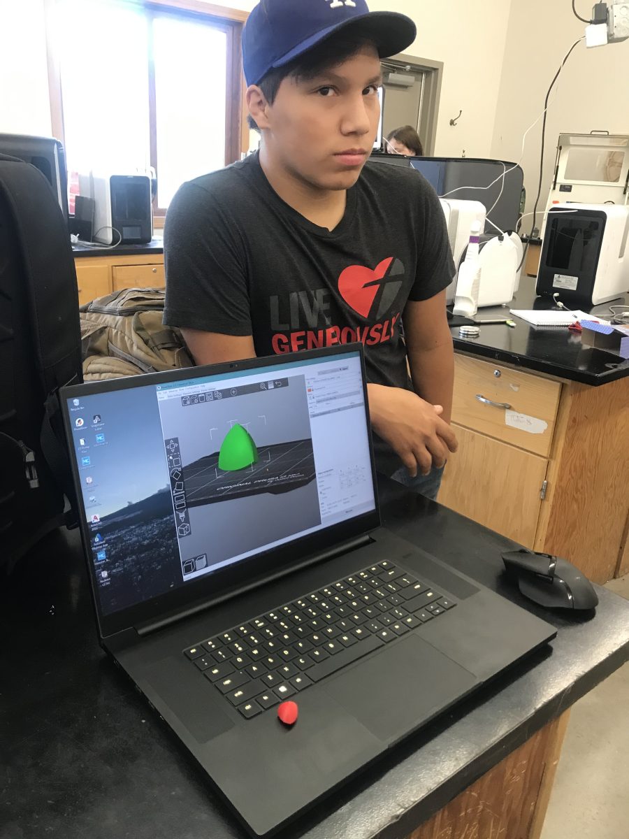 At Sturgis Brown High School, high school student Paul Pulling with a picture of CAD design on computer, printed object.